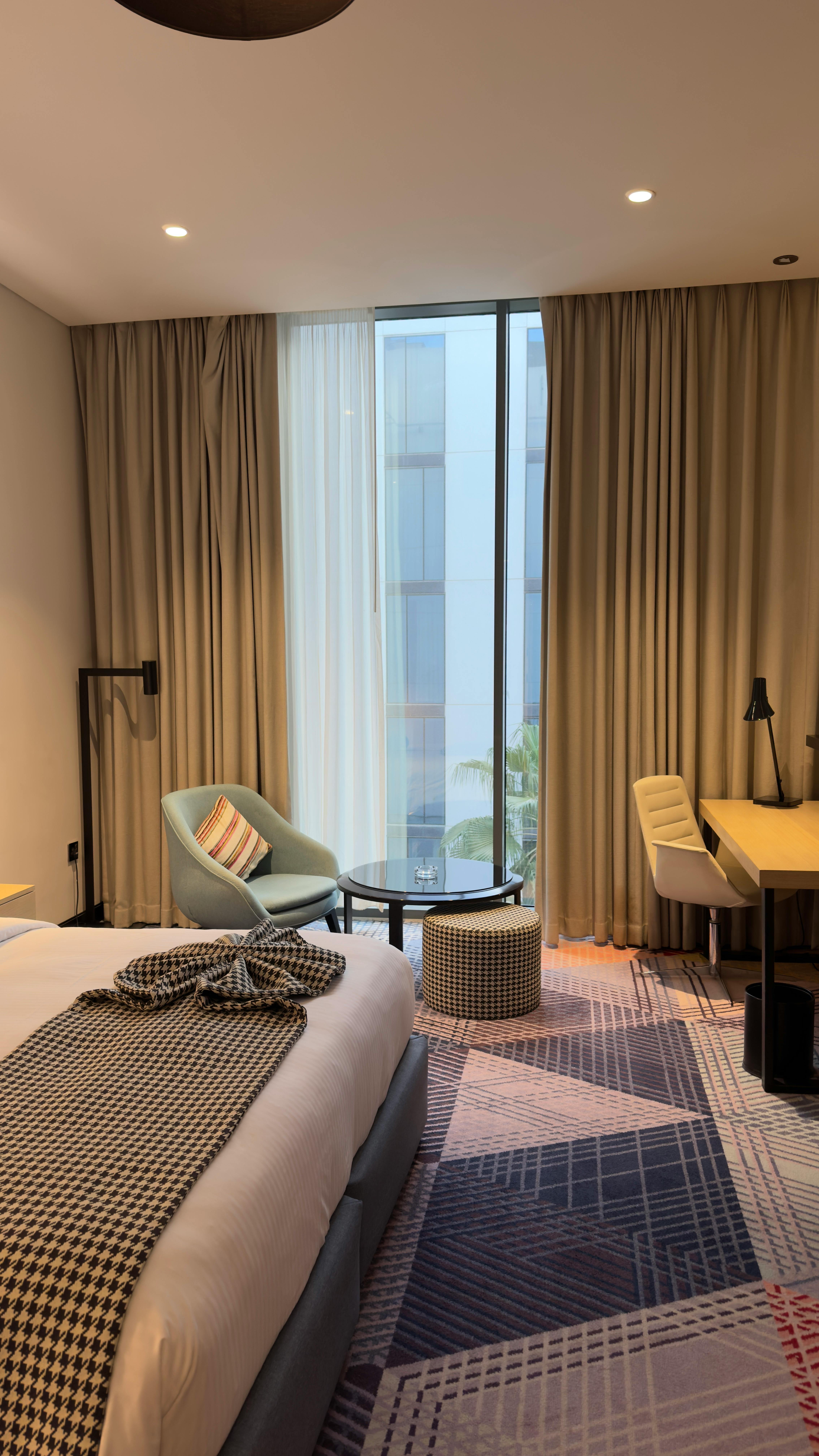 Quarto de hotel com cama arrumada e flores sobre a cama